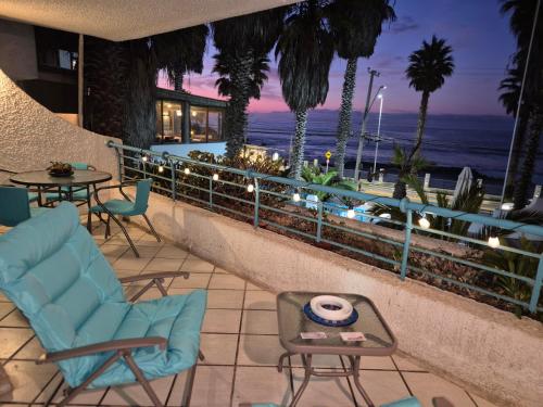 a patio with chairs and tables and a view of the ocean at Departamento playa amarilla concón in Concón
