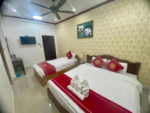 a bedroom with two beds and a ceiling fan at Luangprabang Villa Suan Keo Two in Luang Prabang