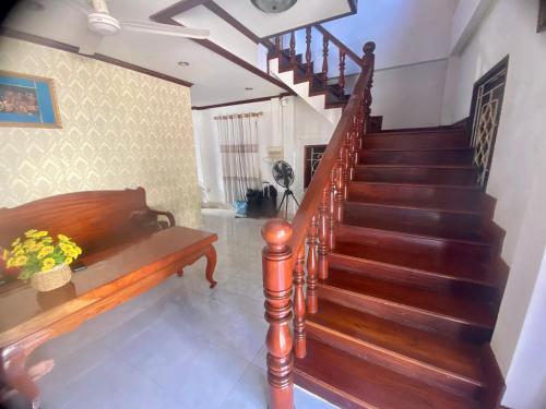 a staircase in a living room with a wooden stair case at Luangprabang Villa Suan Keo Two in Luang Prabang