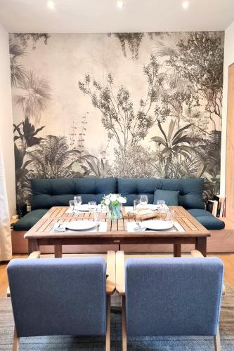 a dining room with a table and a couch at Maison de Charme en centre-ville in Libourne