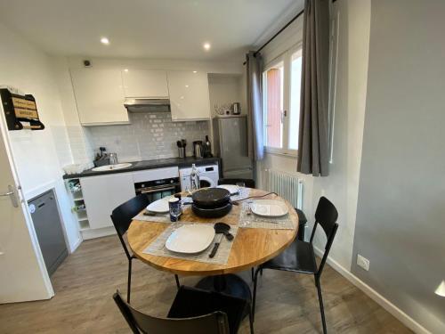 - une cuisine avec une table et des chaises en bois dans la chambre dans l'établissement LE NID DE LA PIRAZ - Parking, Balcon & Netflix !, à Annecy