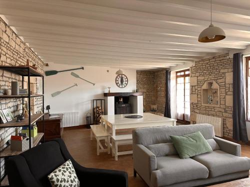 a living room with a couch and a table at Une maraîchine en bord de conche avec barque sans linge de maison in Arçais