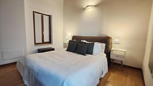 a bedroom with a bed and a window and a night stand at Giardino Giusti House & Court in Verona