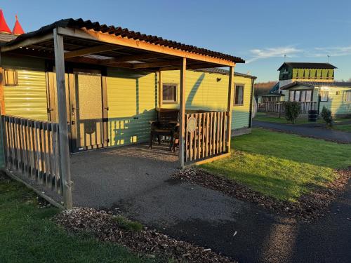 a small yellow house with a wooden gate at Gulliver's Valley, M1, JCT 31 in Rotherham