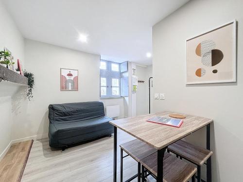 un salon avec une table et une chaise dans l'établissement Appartement tout neuf 4 pers N1, à Riom