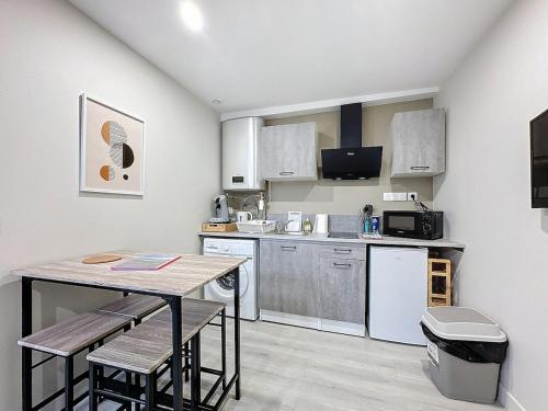 une petite cuisine avec une table et des chaises. dans l'établissement Appartement tout neuf 4 pers N1, à Riom