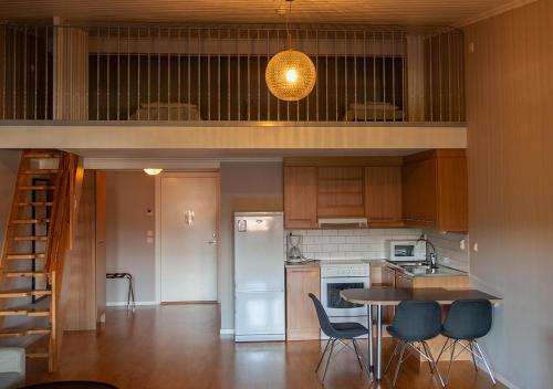 a kitchen with a loft with a table and chairs at Hotell Ronja in Vimmerby
