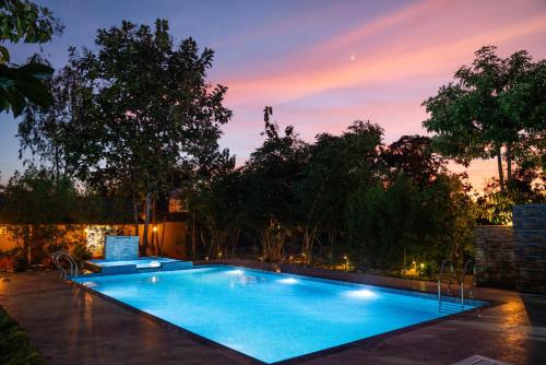 a swimming pool in a backyard at dusk at Wagharanya Resort in Khutwanda