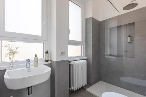 a bathroom with a sink and a toilet and windows at Casa Vespi by Hili in Rome