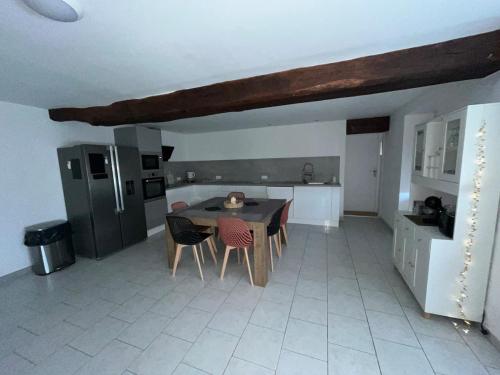 une cuisine avec une table et des chaises dans une pièce dans l'établissement Maison des Gautraies, à Bécon-les-Granits