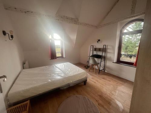 - une chambre avec un lit, une fenêtre et une échelle dans l'établissement Maison des Gautraies, à Bécon-les-Granits