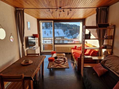 un salon avec un canapé et une table dans l'établissement Résidence LES CHAMOIS - aux pieds des pistes de Chamrousse, à Chamrousse