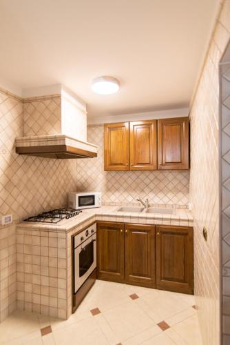a kitchen with wooden cabinets and a stove top oven at Villa Asia in Selva di Fasano