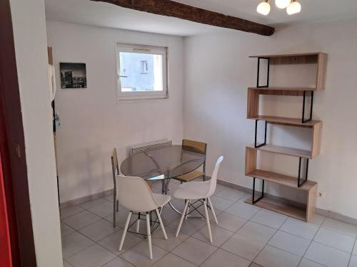 une salle à manger avec une table et des chaises en verre dans l'établissement le duplex charmant et cosy, à Narbonne