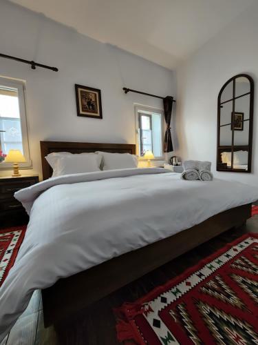 a large white bed in a bedroom with a mirror at Sokak Boutique Hotel in Berat