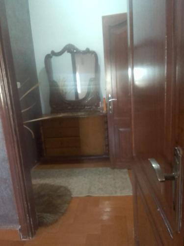 łazienka z lustrem i drewnianą szafką w obiekcie جبيهه w mieście Amman
