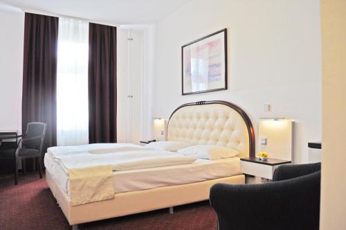 a hotel room with a large bed and a desk at Hotel Prens Berlin in Berlin