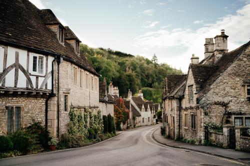 an empty street in a village with stone buildings at The Manor House Hotel and Golf Club in Castle Combe
