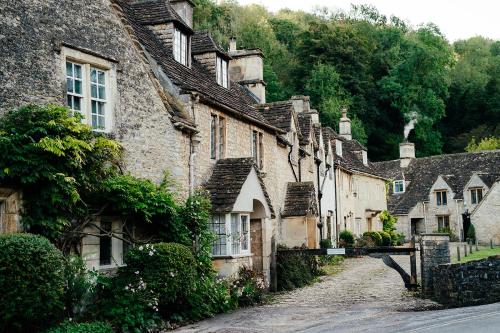 a row of old stone houses on a street at The Manor House Hotel and Golf Club in Castle Combe
