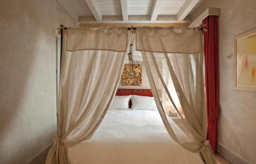a bed with a curtain in a bedroom at La Barchessa di Villa Pisani in Lonigo