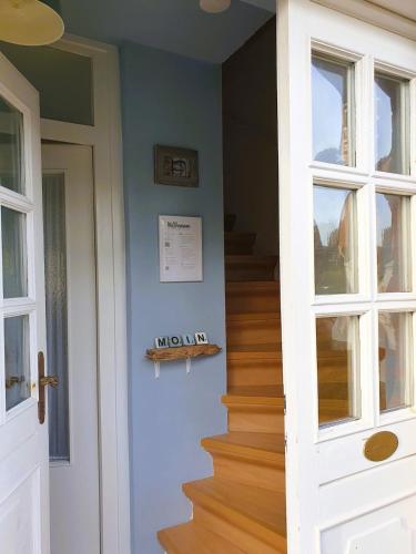 a staircase in a house with a white door at Haus Hanne Sylt Wohnung Obergeschoss in Sylt