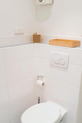 a bathroom with a toilet and a toilet paper dispenser at Haus Hanne Sylt Wohnung Obergeschoss in Sylt