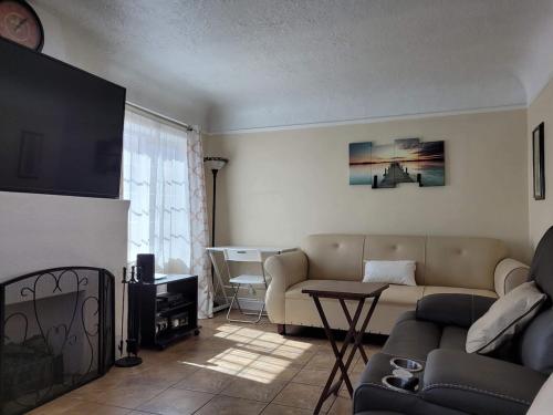 una sala de estar con un sofá y una mesa en Cozy Spacious, free parking, near it all, en South Gate