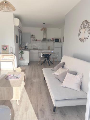 un salon avec un canapé blanc et une table dans l'établissement Jolie maison avec jardin, 2 chambres, à Saint-Jean-de-Fos
