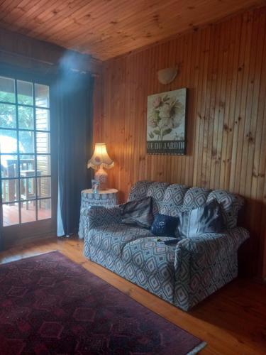 a living room with a couch and a lamp at Emerald Hill Cabin in Mount Pleasant