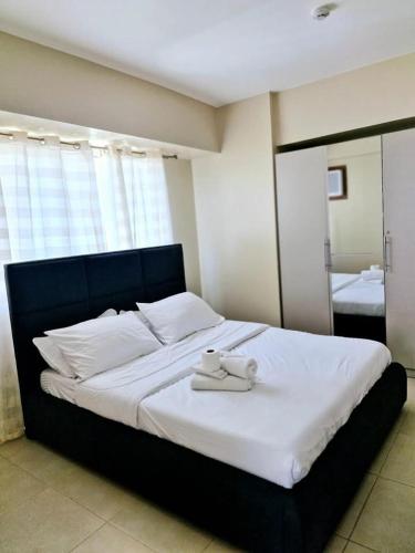 a bed with a teddy bear on top of it at Avida Towers 2 Bedroom by PHI Rentals in Iloilo City
