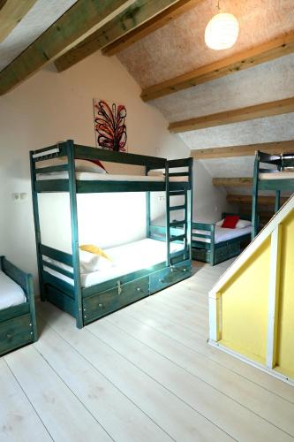 three bunk beds in a room with a staircase at White Rabbit Hostel in Hvar