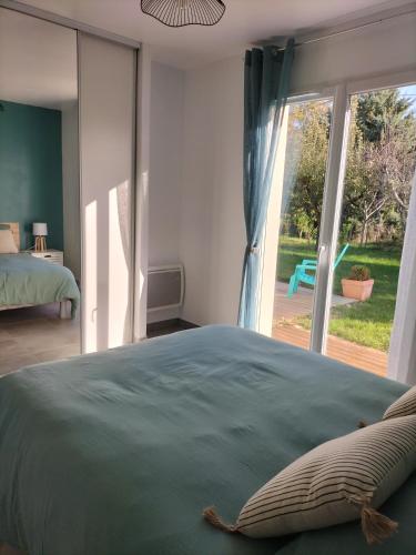 une chambre avec un lit et une grande fenêtre dans l'établissement Gîte Le Pastel Du Midi, à Gaillac