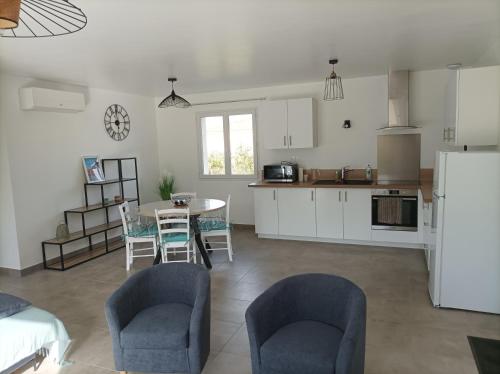 une cuisine avec deux chaises bleues et une table ainsi qu'une cuisine avec une table à manger dans l'établissement Gîte Le Pastel Du Midi, à Gaillac