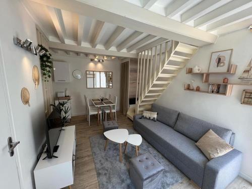 a living room with a blue couch and a table at Cosy Duplex ! Situation centrale - proche plage et commerces - linge de lit et serviettes de toilette compris in Ouistreham