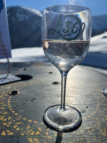 un verre de vin assis au-dessus d'une table dans l'établissement Appartement 4 personnes dans le mythique Paquebot des Neiges à La Plagne, à Aime La Plagne