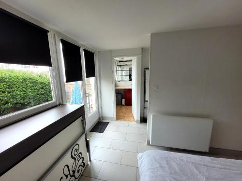 - une chambre avec un lit, une fenêtre et un couloir dans l'établissement Résidence About Malo RDC avec jardin lumineux à 2 pas de la plage, à Dunkerque