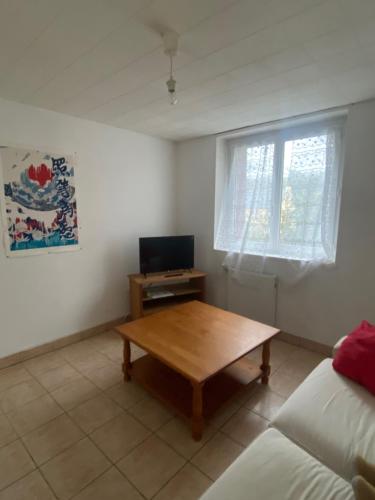 - un salon avec une table en bois et une fenêtre dans l'établissement studio terrasse proche technopole et marine, à Brest