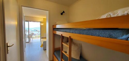 a bunk bed in a small room with a mirror at LE CAPITOLE Vue mer Studio cabine 27m2 2 adultes 2 enfants avec climatisation et garage in Fréjus