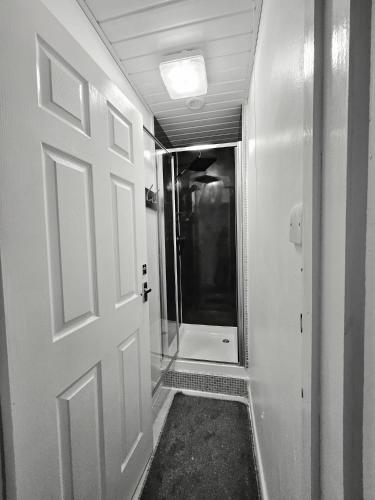 a bathroom with a door and a walk in shower at Inspire Home Stylish Stay E in Cardiff