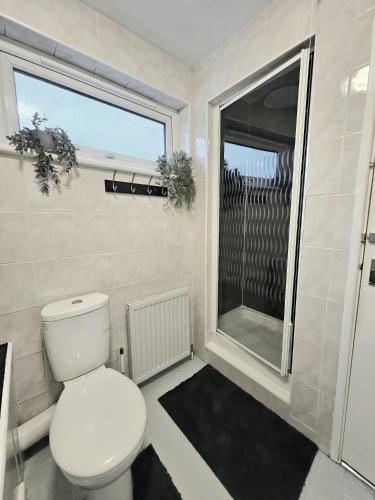 a bathroom with a white toilet and a window at Inspire Home Stylish Stay E in Cardiff
