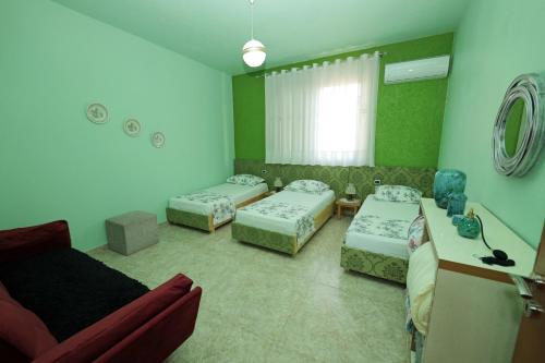 - un salon avec trois lits et un canapé dans l'établissement The house of dreams 2, à Shkodër