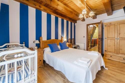 a bedroom with a bed with blue and white stripes at El Pico in Canalejas de Peñafiel