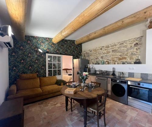 une cuisine et un salon avec une table et un canapé dans l'établissement Maison provençale proche du lac, à Codolet