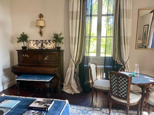 a living room with a piano and a table at CHATEAU ROUTGER in Sainte Marie de Gosse