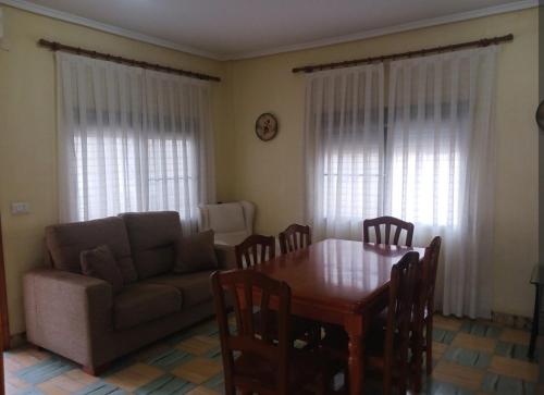 a living room with a table and a couch at Casa a 200 metros de la playa 10 PAX in Almazora