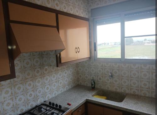 a kitchen with a stove and a sink and a window at Casa a 200 metros de la playa 10 PAX in Almazora