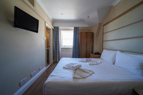 a hotel room with a bed with towels on it at Royal Eagle Hotel in London