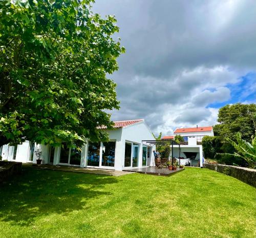 ein weißes Haus mit einem großen Hof in der Unterkunft Time to Travel to Terceira in Pesqueiro