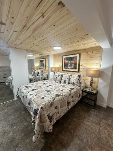 a bedroom with a large bed with a wooden ceiling at Pointe Calumet, 30 minutes de Montréal max 8 pers in Pointe-Calumet