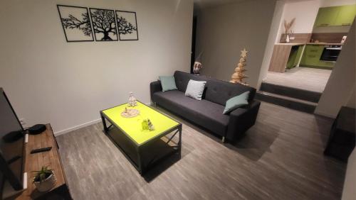 un salon avec un canapé et une table dans l'établissement De l'herbe jusqu'aux genoux - appartement 60 m2, à La Vancelle
